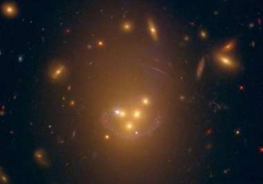 The blue halo around the four colliding galaxies is actually the distorted image of the one far behind them.